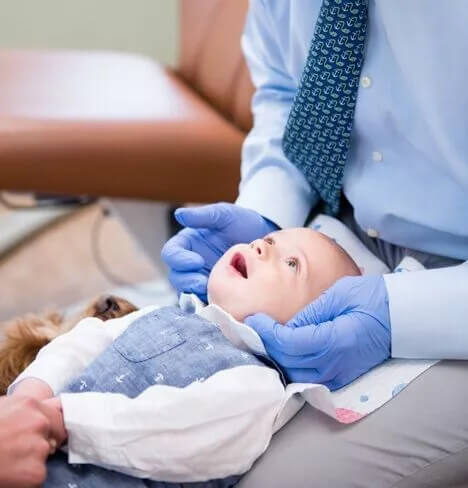 Image of a baby with one of out Pediatric Dentists